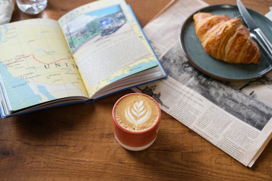 Flat lay of coffee, croissant, map, and newspaper on a wooden table in Istanbul.